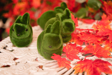 green grass decoration Rabbits on white retro table in the autumn countryside