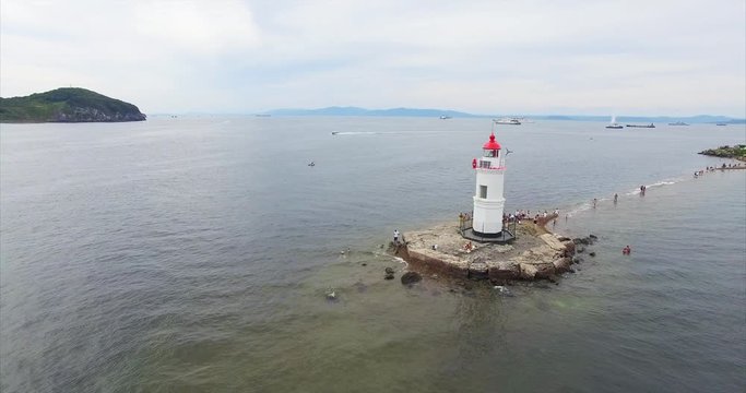 Aerial static view of Tokarevsky lighthouse in Vladivostok and tourists came here to take pictures of nice landscape. Russia