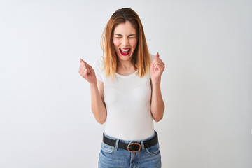 Beautiful redhead woman wearing casual t-shirt standing over isolated white background excited for success with arms raised and eyes closed celebrating victory smiling. Winner concept.