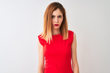 Redhead businesswoman wearing elegant red dress standing over isolated white background skeptic and nervous, frowning upset because of problem. Negative person.