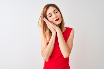 Redhead businesswoman wearing elegant red dress standing over isolated white background sleeping tired dreaming and posing with hands together while smiling with closed eyes.