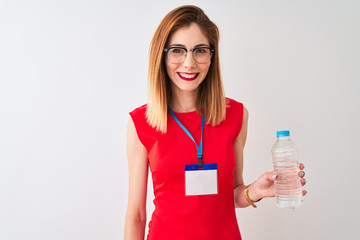 Redhead businesswoman wearing id card drinking water over isolated white background with a happy face standing and smiling with a confident smile showing teeth