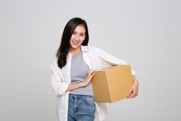 Delivery, relocation and unpacking. Smiling young woman holding cardboard box isolated