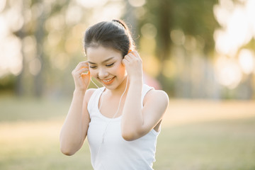 Beautiful Young Woman with earphones Outdoors. Enjoying Music