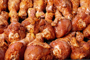 skin on raw organic chicken drumsticks with spices ready to be cooked