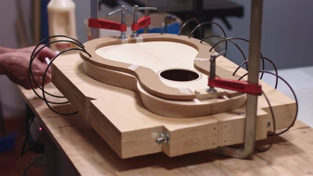 Luthier uses springs to clamp guitar body