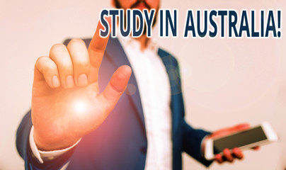 Conceptual hand writing showing Study In Australia. Concept meaning going into foreign country order complete your studies Businessman pointing with pen in empty copy space