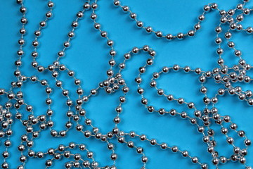 texture silver christmas garland beads on a blue background