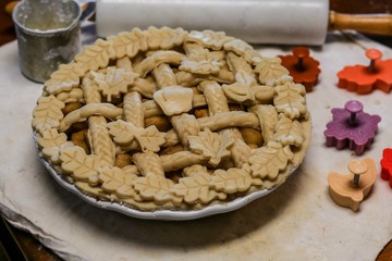 Selective Focus Closeup of a decorative unbaked pie crust with braids and autumn leaves