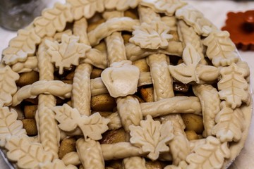 Selective Focus Closeup of a decorative unbaked pie crust with braids and autumn leaves