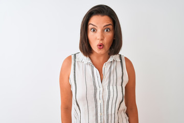 Fototapeta premium Young beautiful woman wearing casual striped shirt standing over isolated white background afraid and shocked with surprise expression, fear and excited face.