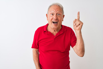 Senior grey-haired man wearing red polo standing over isolated white background pointing finger up...