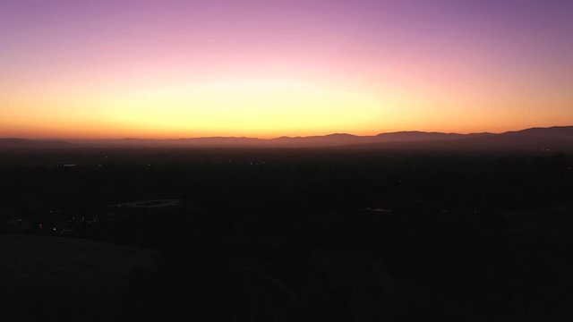 Stunning predawn sunrise morning with purple, blue, orange, amber and white colors across a smokey dew laden landscape.