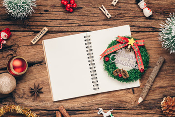 Top view of blank notebook on grunge wood  background with xmas decorations. Mockup Christmas background with notebook for wish list or to do list. Flat lay with copy space.