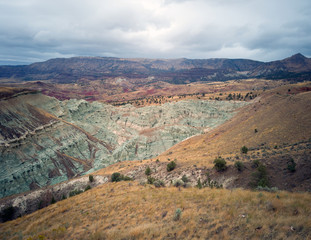 Breathtaking views of the grey-blue badlands and the scenic John Day River Valley and Mountains from the rustic Blue Basin Overlook Trail at the John Day Fossil Beds Sheep Rock Unit in Kimberly Oregon