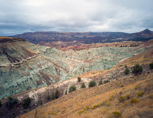 Breathtaking views of the grey-blue badlands and the scenic John Day River Valley and Mountains from the rustic Blue Basin Overlook Trail at the John Day Fossil Beds Sheep Rock Unit in Kimberly Oregon