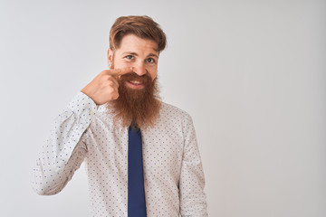 Young redhead irish businessman standing over isolated white background Pointing with hand finger to face and nose, smiling cheerful. Beauty concept