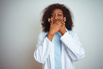 Young african american doctor woman wearing stethoscope over isolated white background shocked covering mouth with hands for mistake. Secret concept.