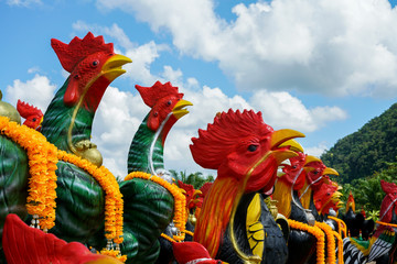 Lined of chicken statues in Outdoor with sun light with copy space, Chicken statues are the traditional beliefs of Thai Buddhism people.