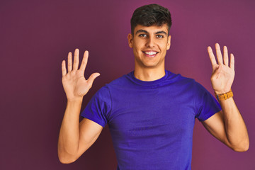 Young indian man wearing t-shirt standing over isolated purple background showing and pointing up with fingers number nine while smiling confident and happy.