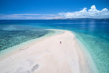 Woman on remote island in Fiji overlooking blue coral reef	