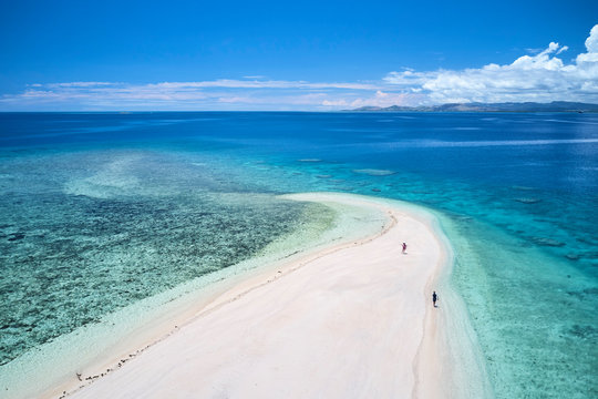 Man and Woman on remote island in Fiji overlooking blue coral reef	