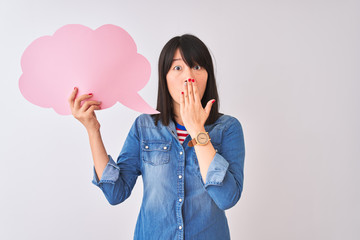 Young beautiful Chinese woman holding cloud speech bubble over isolated white background cover mouth with hand shocked with shame for mistake, expression of fear, scared in silence, secret concept