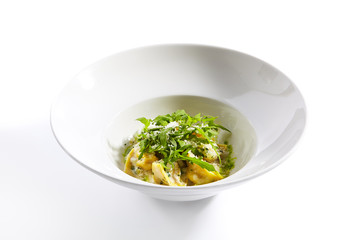 Tortellini with rabbit meat pesto sauce and arugula close up