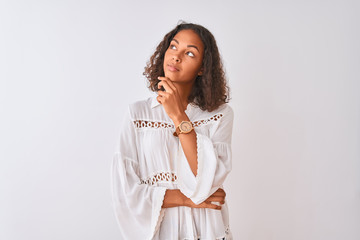 Young brazilian woman wearing shirt standing over isolated white background with hand on chin...
