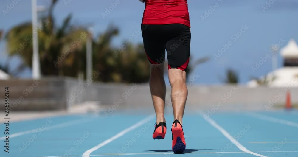 Wall mural Sprinting man sprinter running warming up jogging training on athletics track and field stadium Male athlete runner in intense sprint exercise. Run sport concept. SLOW MOTION 59.94 FPS.