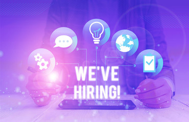Conceptual hand writing showing We Are Hiring. Concept meaning recently you employ someone or pay someone to do particular job Female human wear formal work suit presenting smart device
