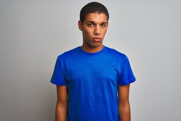 Young handsome arab man wearing blue t-shirt standing over isolated white background depressed and worry for distress, crying angry and afraid. Sad expression.