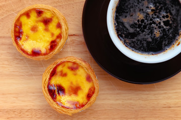 top view fresh portuguese egg tarts with cup of coffee nearby