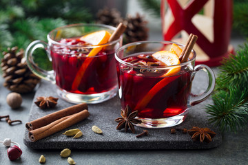 Mulled red wine with spices. Christmas decoration. Grey stone background. Close up.