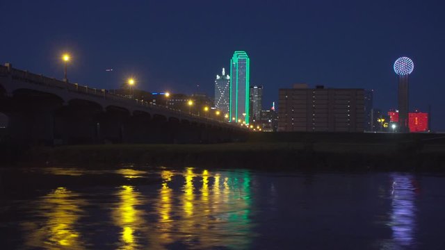 4K - Time Lapse - Dallas Skyline at NIGHT with the Trinity River in the foreground with Rushing water in the foreground.