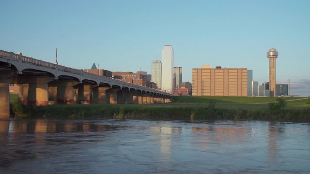 4K - Dallas Skyline with the Trinity River in the foreground during sunset. - FAST Moving Water