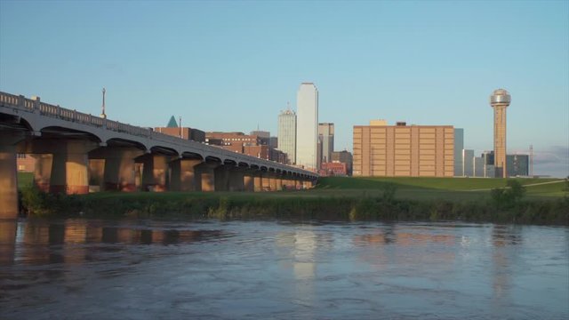 Dallas Skyline with the Trinity River in the foreground during sunset. - FAST Moving Water - 1080p
