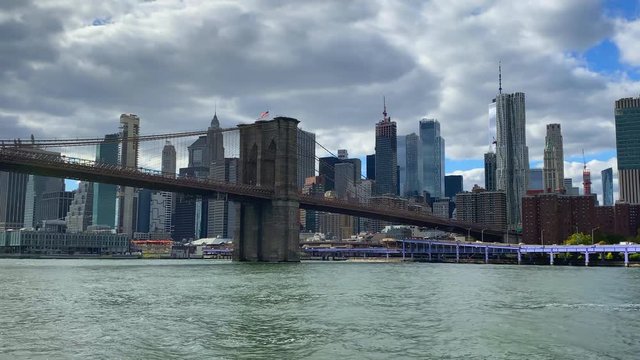 Brooklyn Bridge Manhattan New York. Filmed from boat wide angle approaching on Hudson river.  Skyline background.
