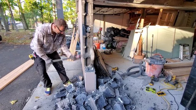 Demolition of concrete wall. Breaking concrete blocks with sledge hummer