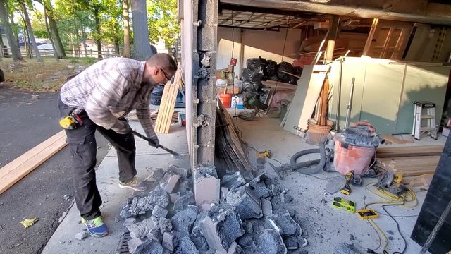 Demolition of concrete wall. Breaking concrete blocks with sledge hummer