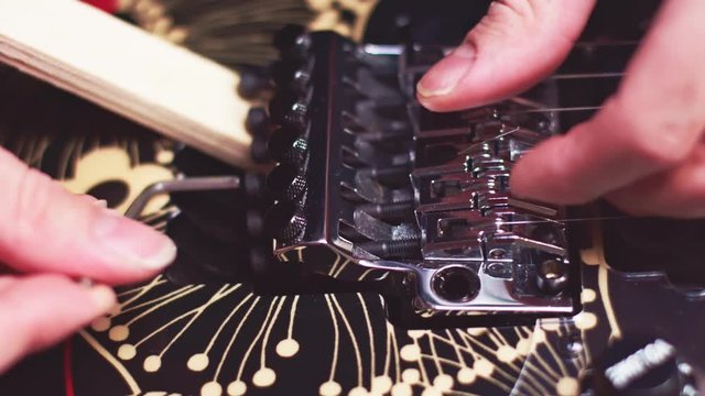 Close up of luthier changing guitar strings