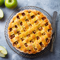 Apple pie on a cooling rack. Grey background. Close up. Top view.