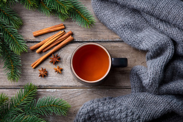Cup of tea with spices. Winter hot beverage. Grey wooden background. Top view.