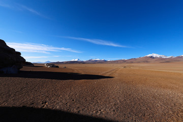 Fototapeta na wymiar Landscape of Siloli Desert. Snow-capped volcanoes and desert landscapes in the highlands of Bolivia. Andean landscapes of the Bolivia Plateau