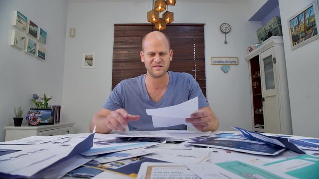 Man frustrated and irritated by his paperwork and gulping the same in agitation. Eates the paper out of frustration.Concept of frustration, stress, and irritation.