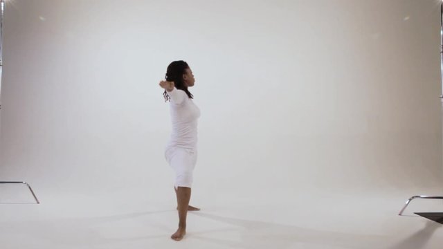 A Black yogini going through yoga warrior asanas then ending in triangle pose.