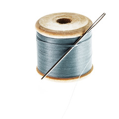 wooden spool of thread with needle