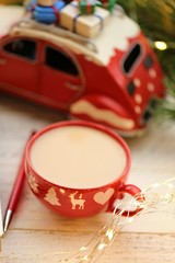 Christmas time. Christmas tea in a red cup, red decorative machine,  wooden tree,  garland on shabby chic background.Winter holidays.