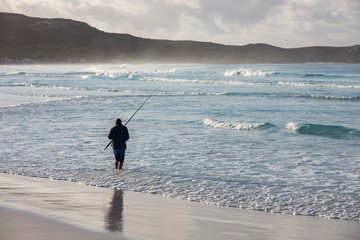 Unidentifiable fisherman in the surf at Lucky Bay beach, located near Esperance in Western Australia