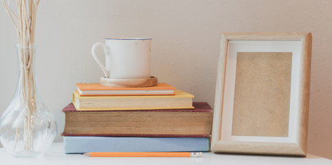 Comfortable workspace with book and mock up frame and a cup of coffee